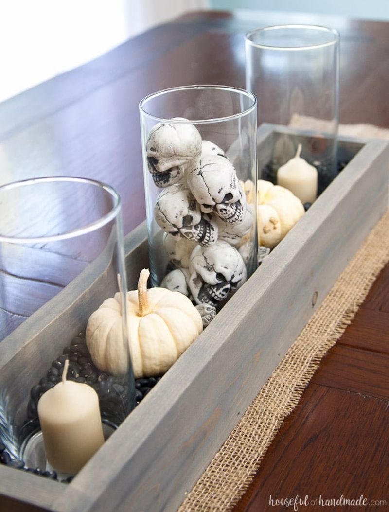Make a simple Halloween table centerpiece from scraps and dollar store skulls in a wooden tray.