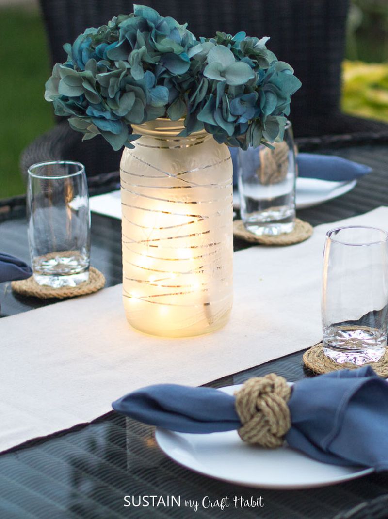 Assemble this centerpiece simply by adding twinkle lights and artificial flowers inside of a mason jar