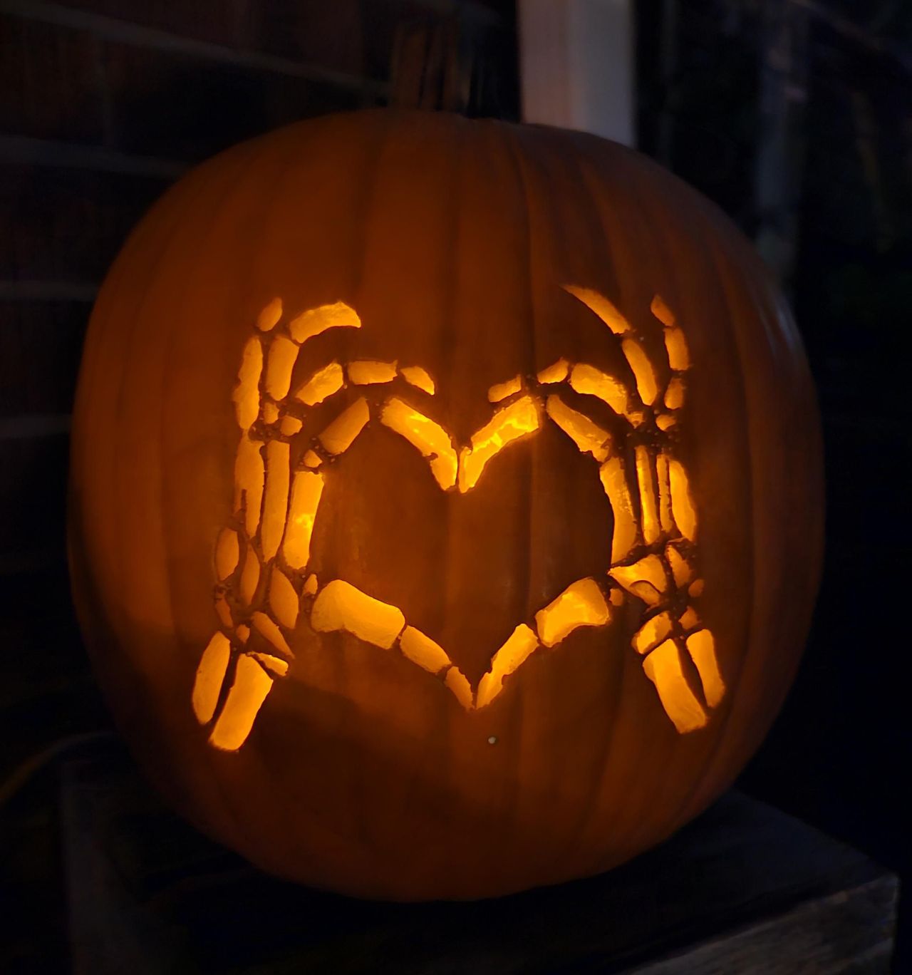 Skeleton hands making love sign carved pumpkin