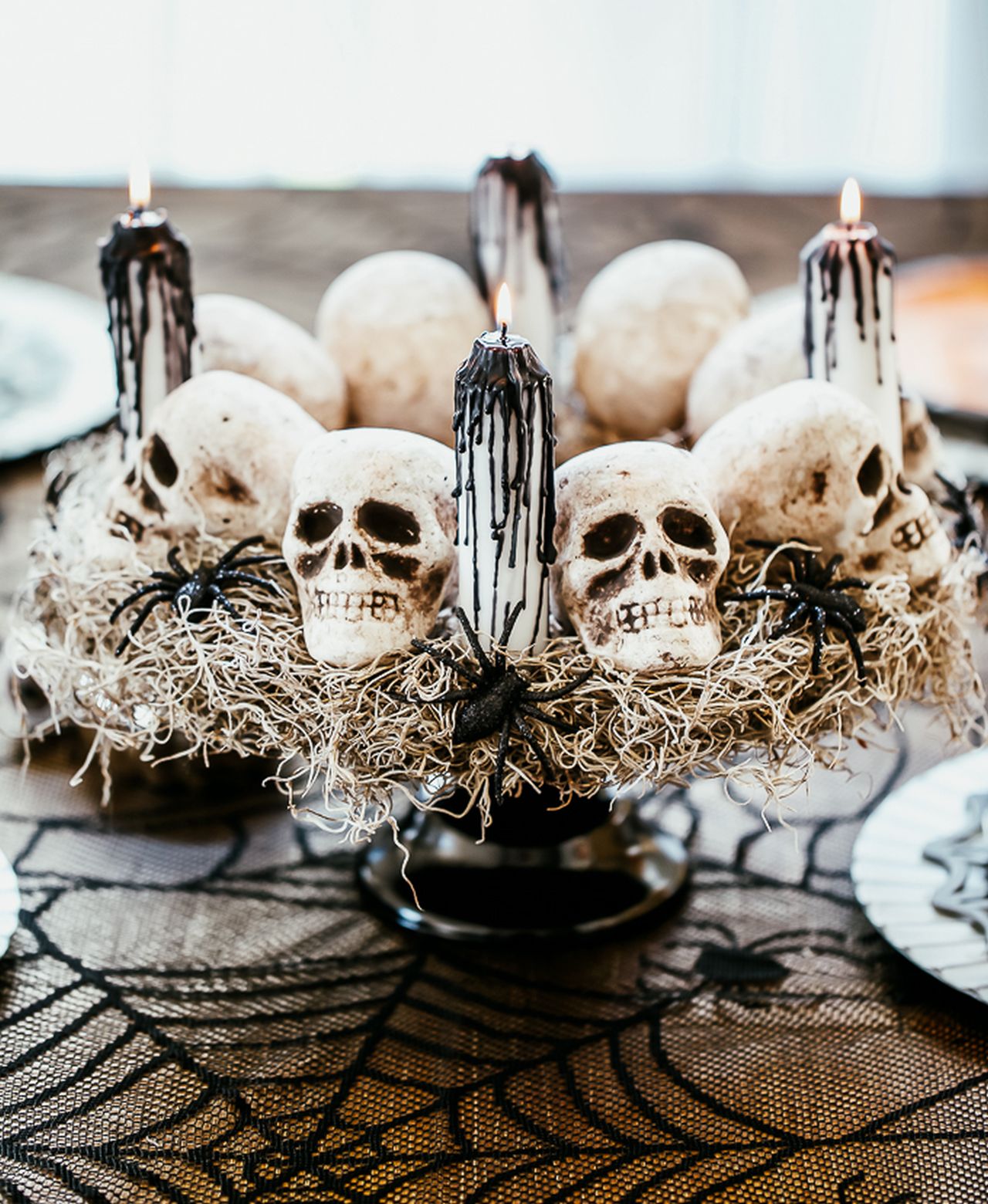 black and white Halloween table centerpiece using skulls and candles
