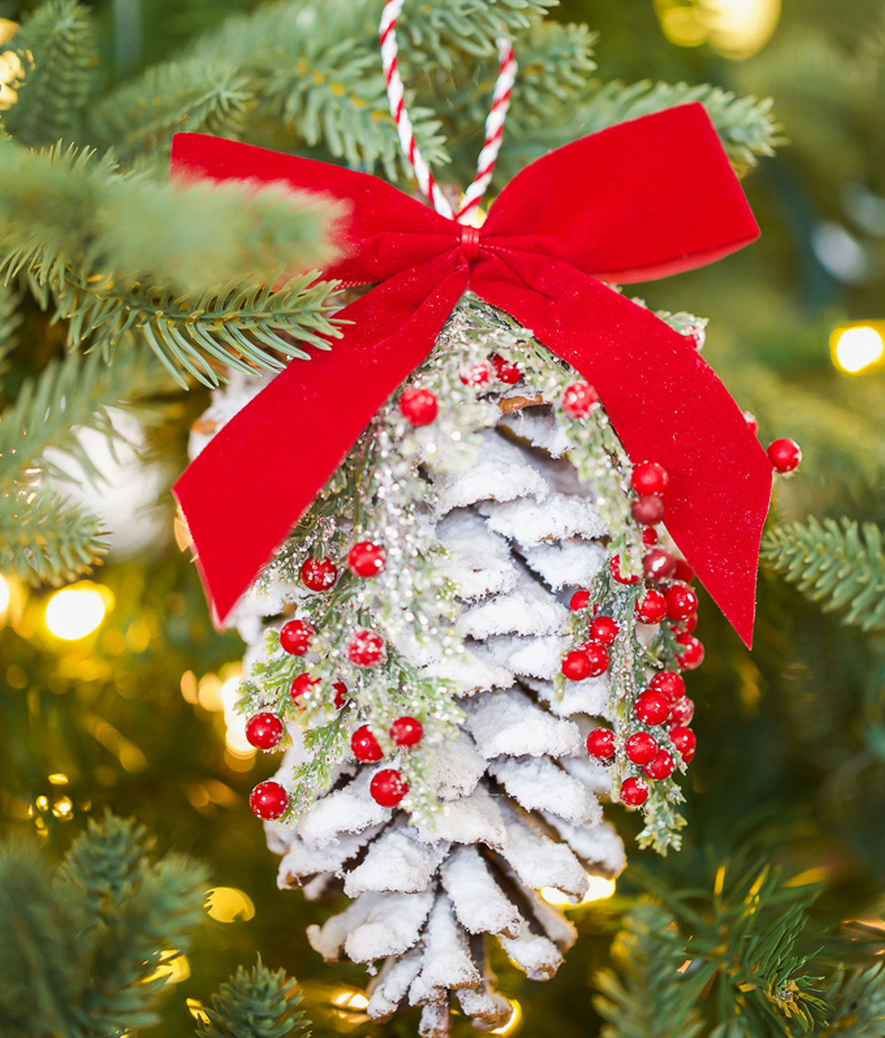 Flocked Pinecone Hanging Ornament decorated With Frosted Christmas Greenery and Berries