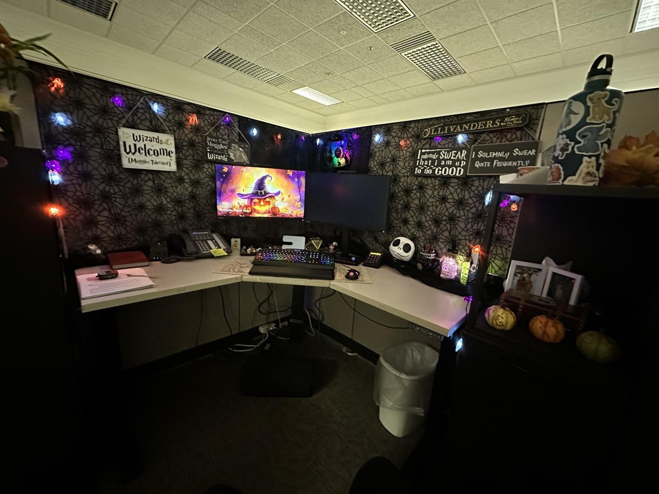 Cubicle walls covered with spider web mesh, The Alice and Wonderland record clock, three sparkly pumpkins and lights