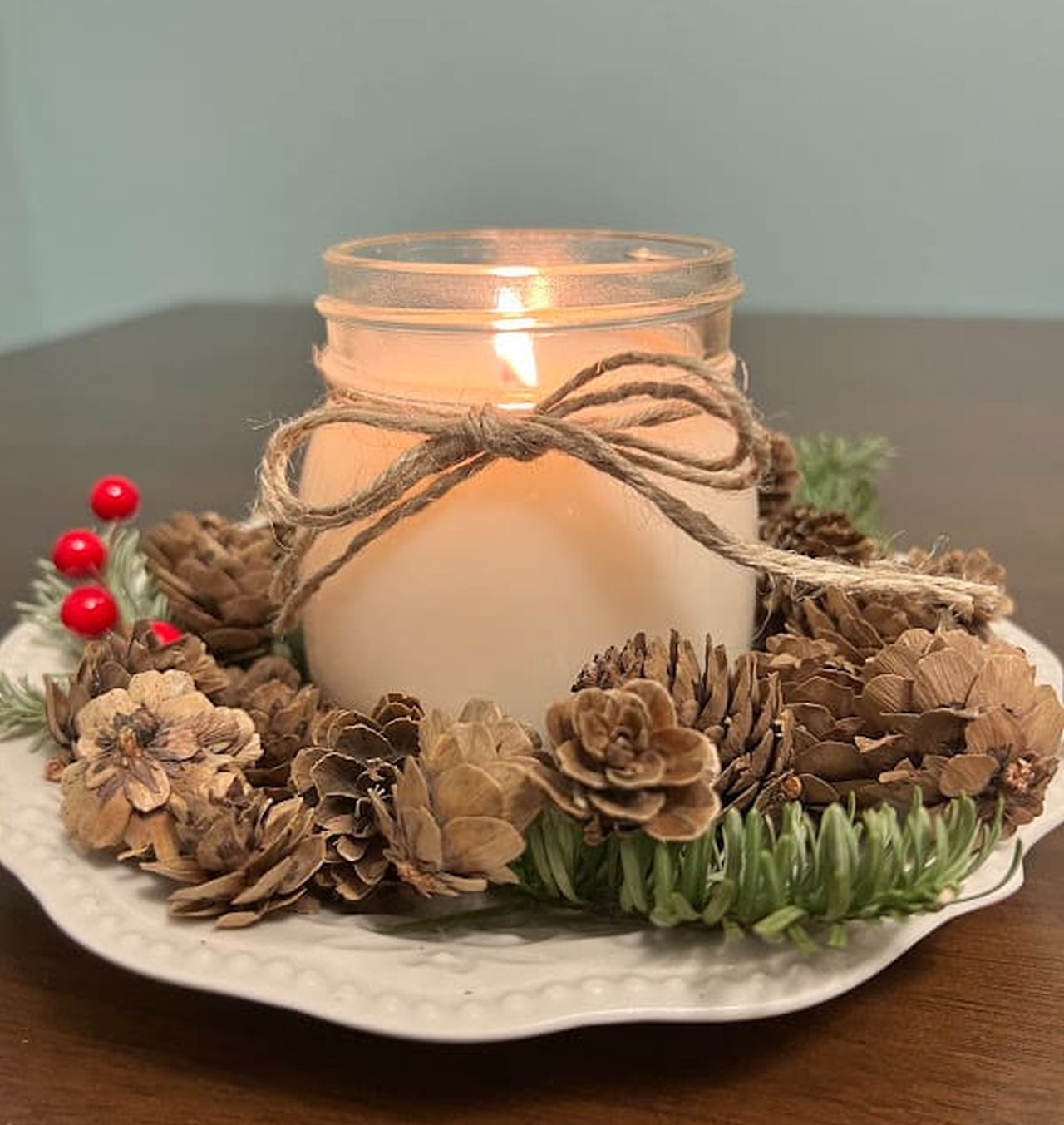 Table centerpiece with mini pine cones and lighted mason jar