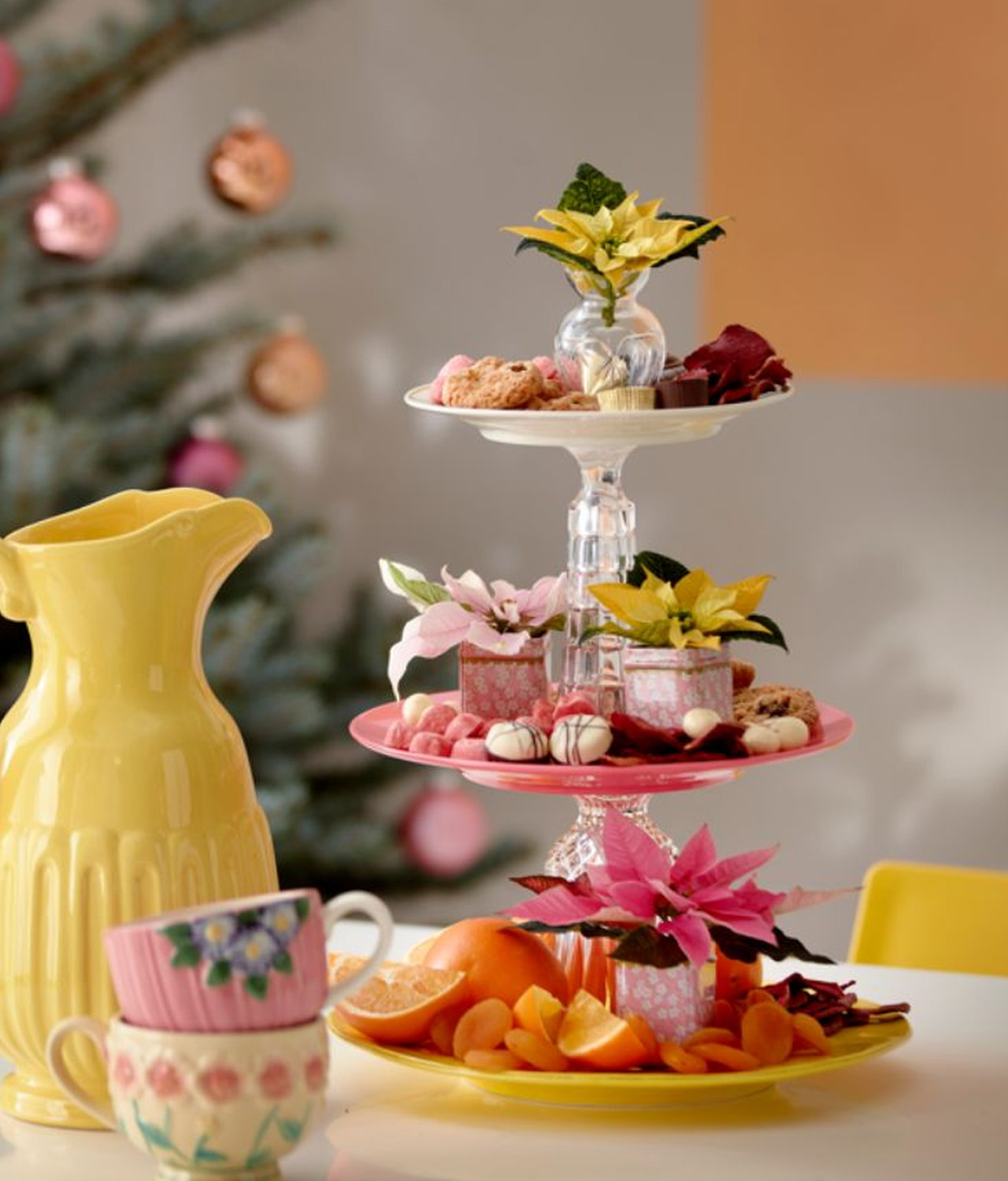 Three-tiered cake stand decorated with pastel poinsettia flowers