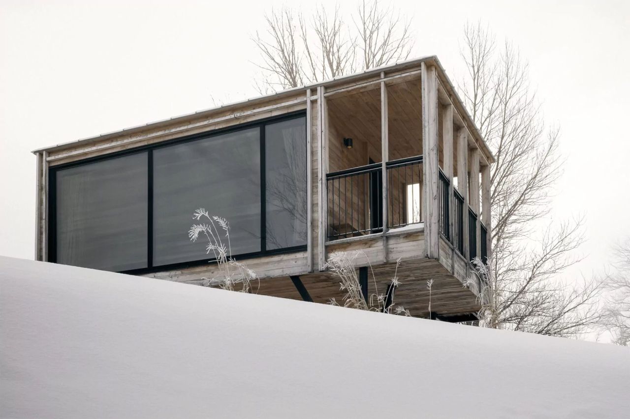 This Stilted Modular Residence Makes Best Out of Its Location - big windows on the front in living room