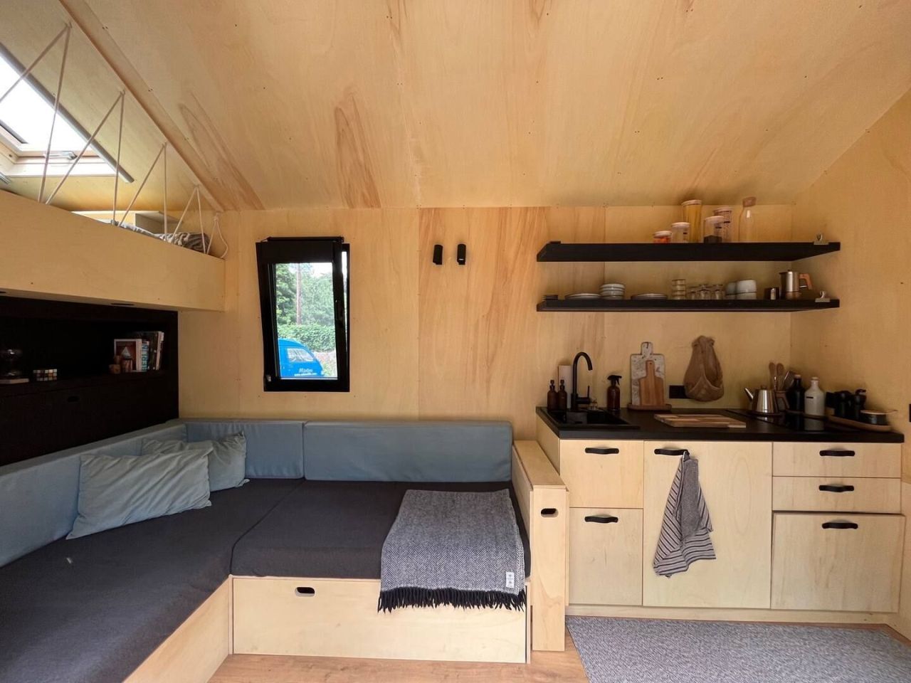 This Tiny House Features a Wide Corner Sofa That Doubles as Bed in Night