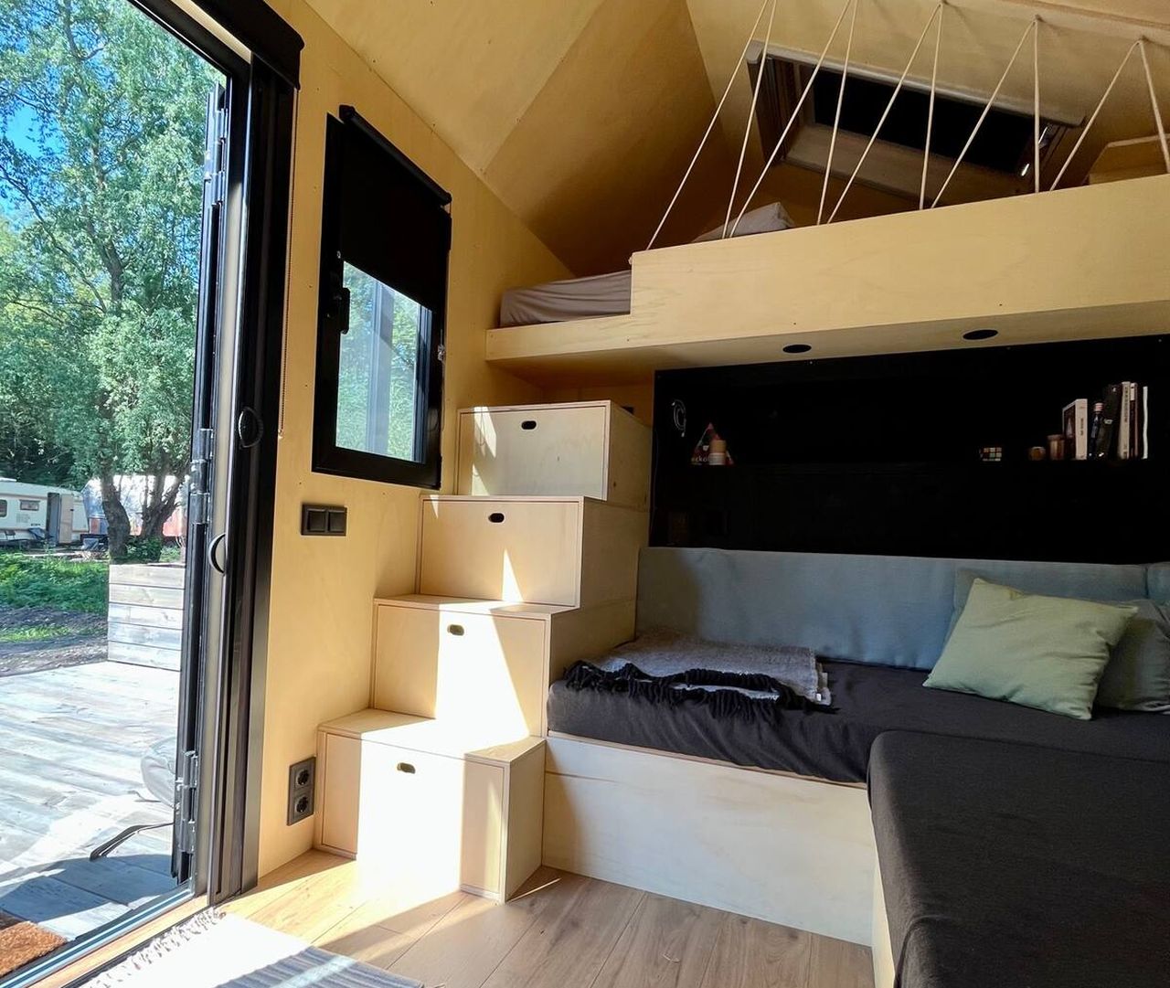 This Tiny House Features a Wide Corner Sofa That Doubles as Bed in Night