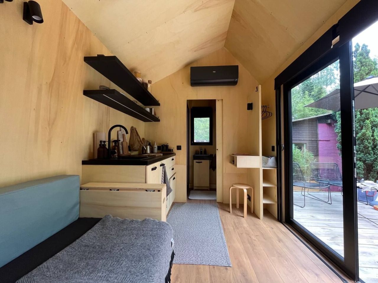 This Tiny House Features a Wide Corner Sofa That Doubles as Bed in Night