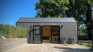 This Tiny House Features a Wide Corner Sofa That Doubles as Bed in Night