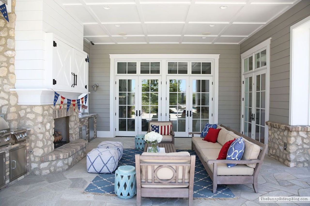 Red and blue rugs, pillows, and poufs create a cozy and patriotic outdoor decor theme for 4th of July