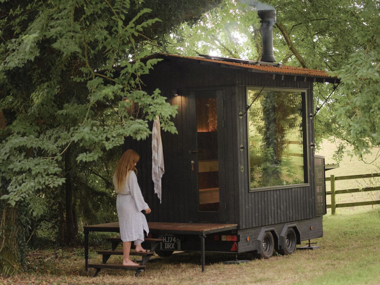 Aquila Mobile Sauna on Wheels by Out of The Valley - a woman entering inside
