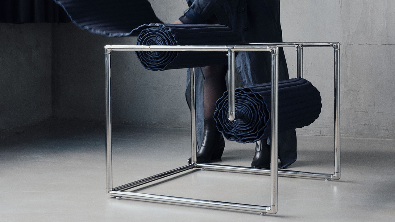 The designer Caroline Chao showing how to roll the padded denim cushion in the Roll-up Chair