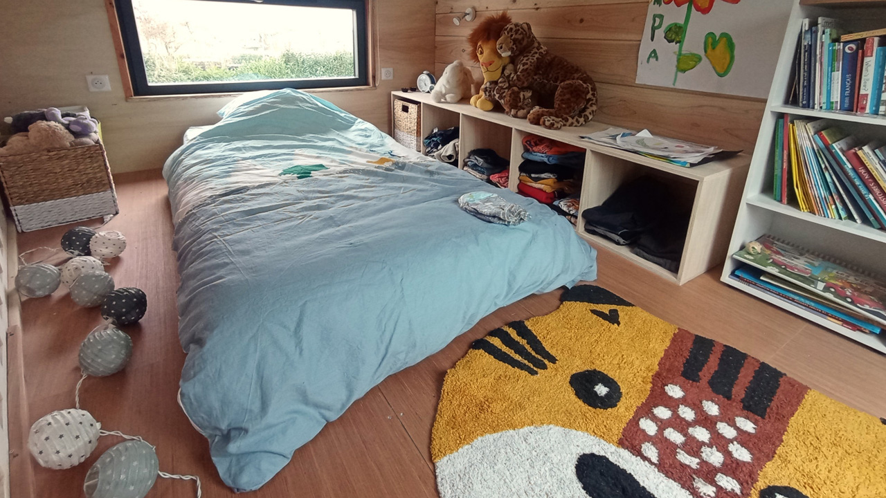 The children's room looks playful and cozy with easily accessible storage.