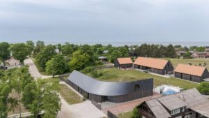 Pāvilosta House’s Curved Slate Roof Looks as if Shaped by Wind and Wave Pāvilosta House’s Curved Slate Roof Looks Like as if it Shaped by Sea Air and Water