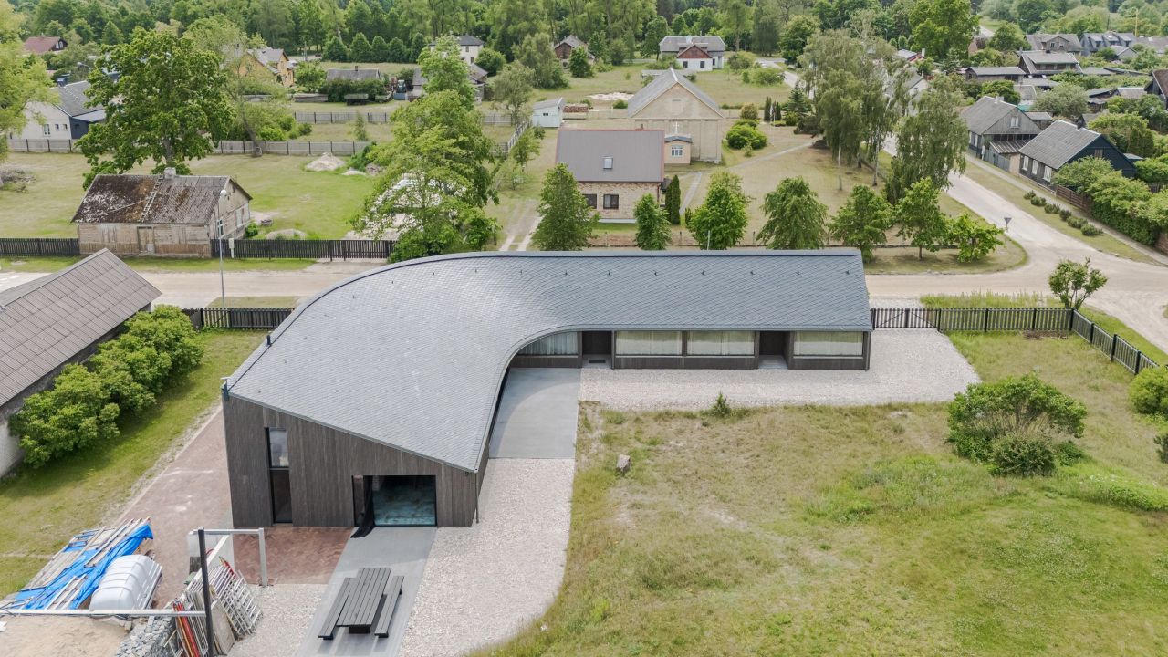 Pāvilosta House’s Curved Slate Roof Looks Like as if it Shaped by Sea Air and Water