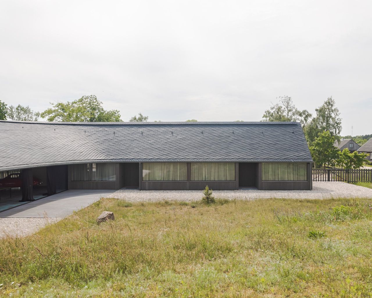 Pāvilosta House’s Curved Slate Roof Looks Like as if it Shaped by Sea Air and Water