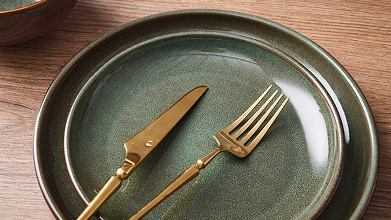 Golden spoon and forks complement the glossy dinnerware really well