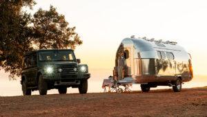 Bowlus Endless Highways Frontier Edition Travel Trailer Features Rustic Interiors with 4x4 vehicle set up with a table and chairs