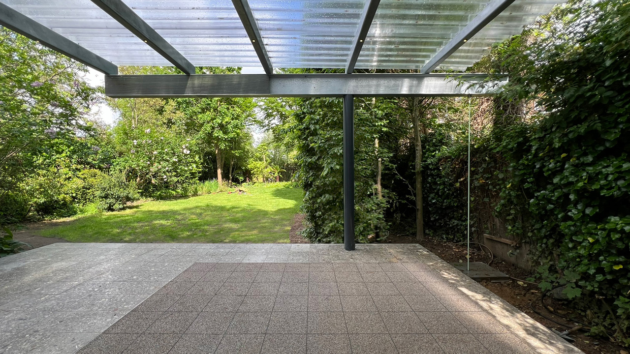 The canopy shelters the patio of the garden outbuilding
