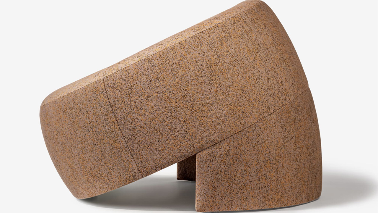 The tilted armchair rests on semi-cylindrical base