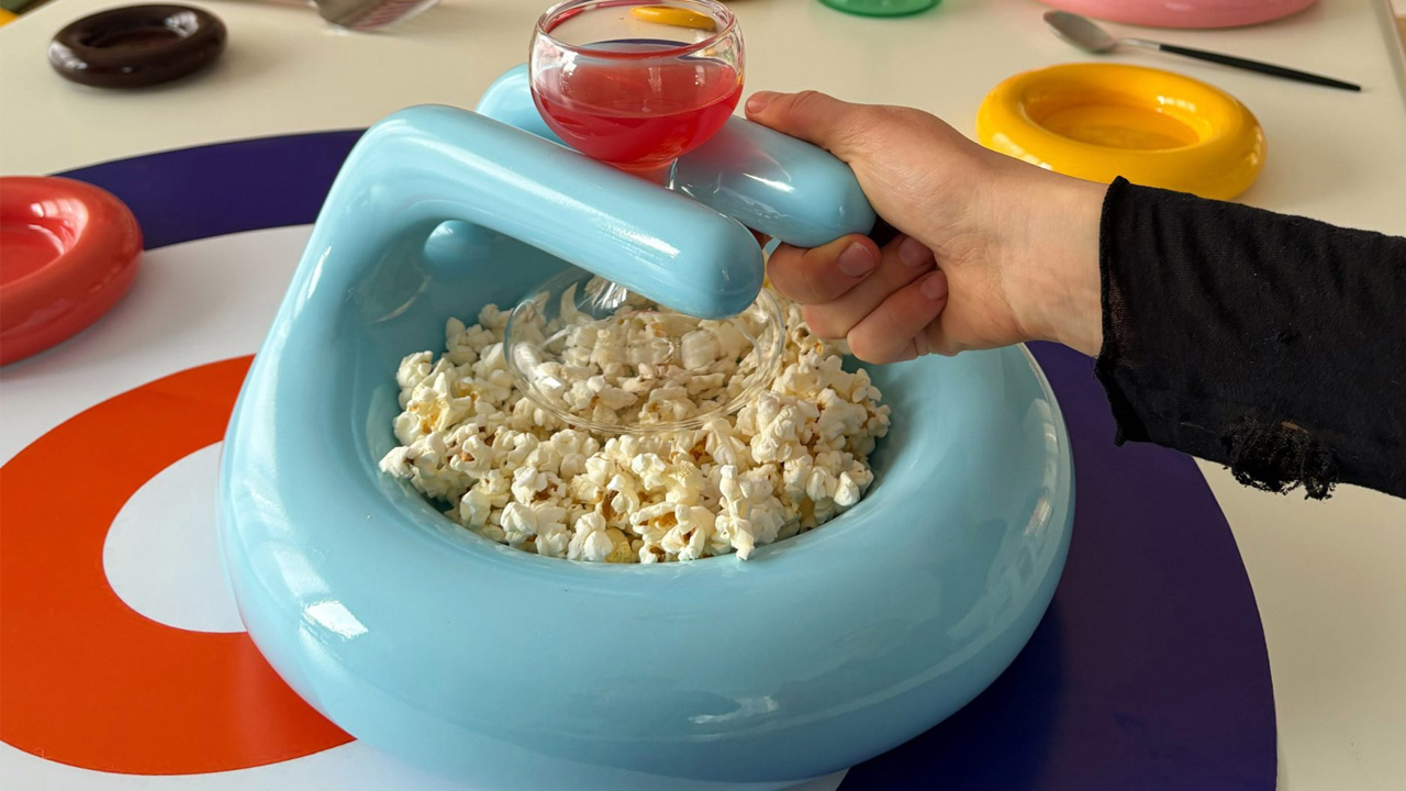 You can place a wine glass in the tubular handle of the bowl