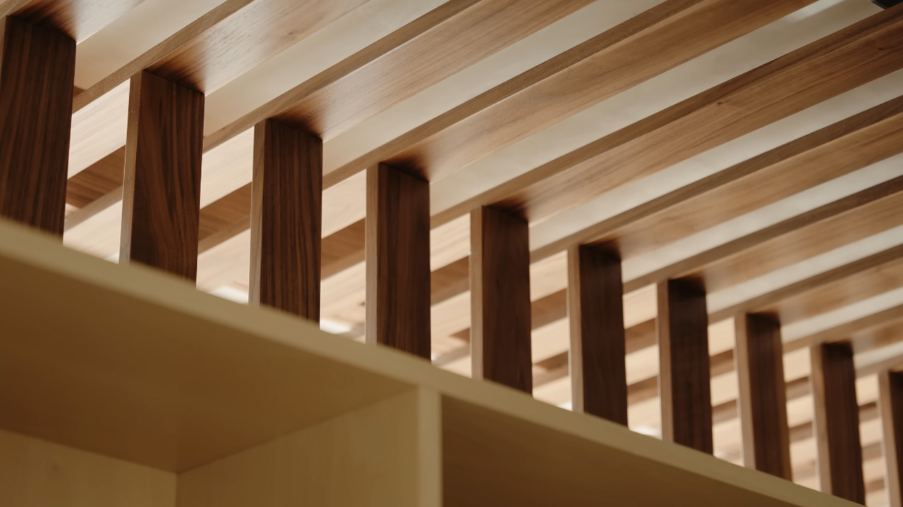 Slatted wooden ceiling structure that doubles as a functional design element