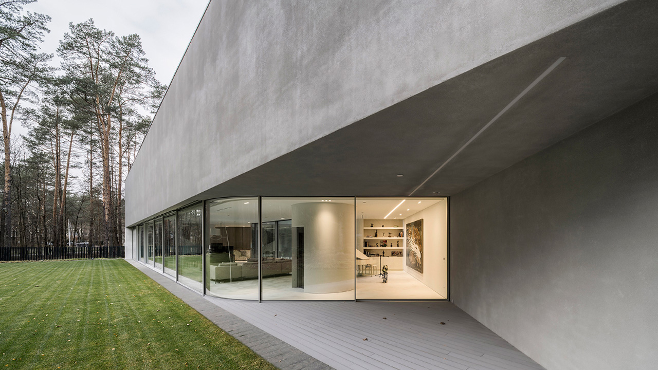 The atrium glows softly and contrasts against the monolithic shell