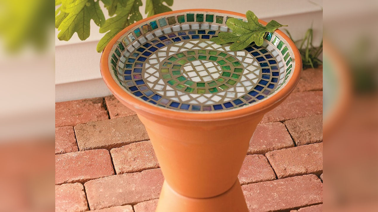 The shiny tiles of DIY Mosaic Birdbath reflects light beautifully