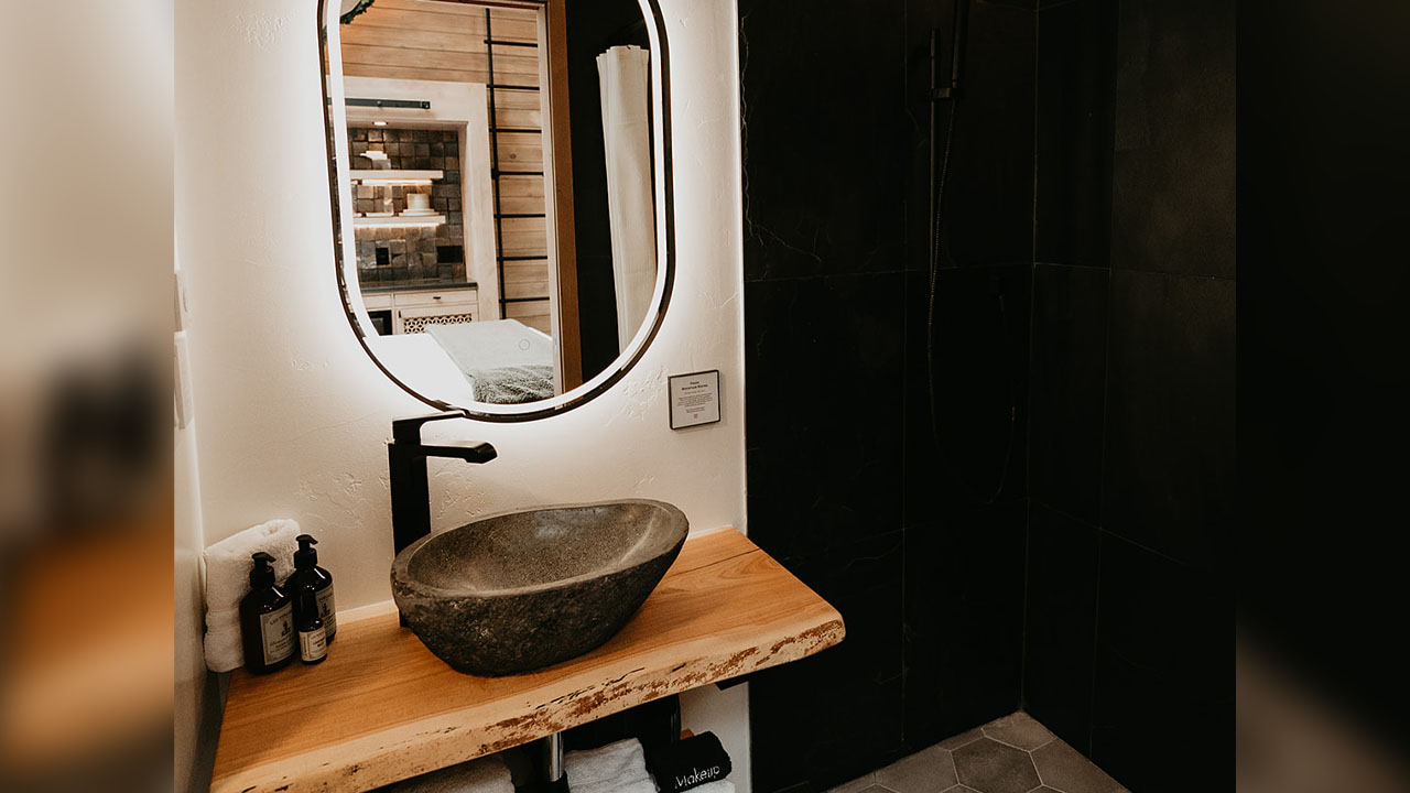 The stone sink looks like a boulder of mountain sitting on the vanity sink of luxury treehouse hotel