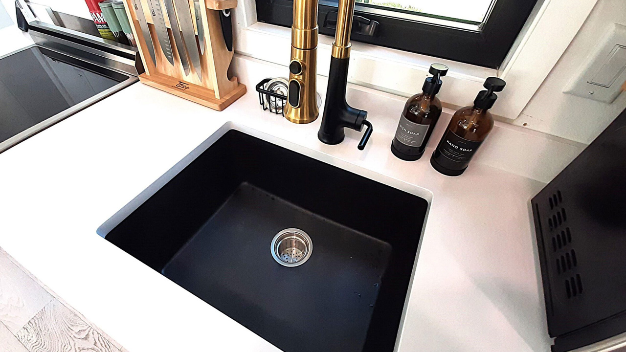 The black sink contrasts against the light countertop