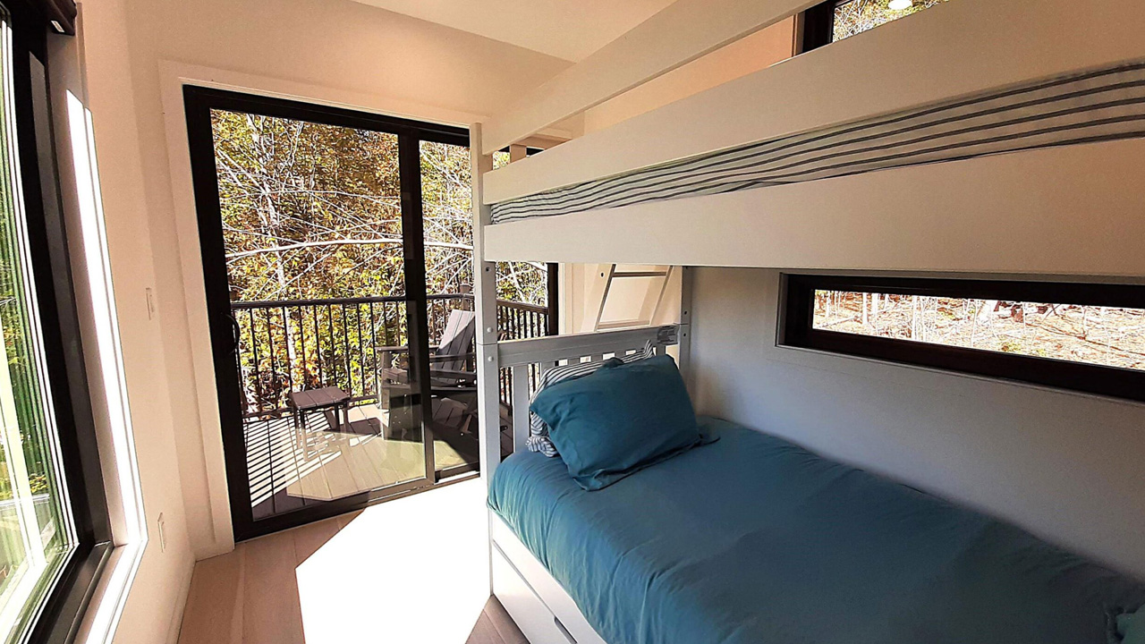 The bunk bed in the bedroom leads to the balcony via the sliding glazed door