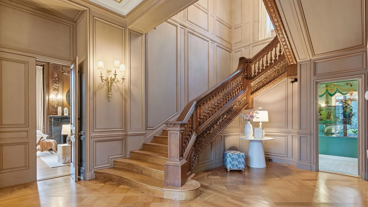 The grand hand-carved banister staircase remains the focal point of the mansion.