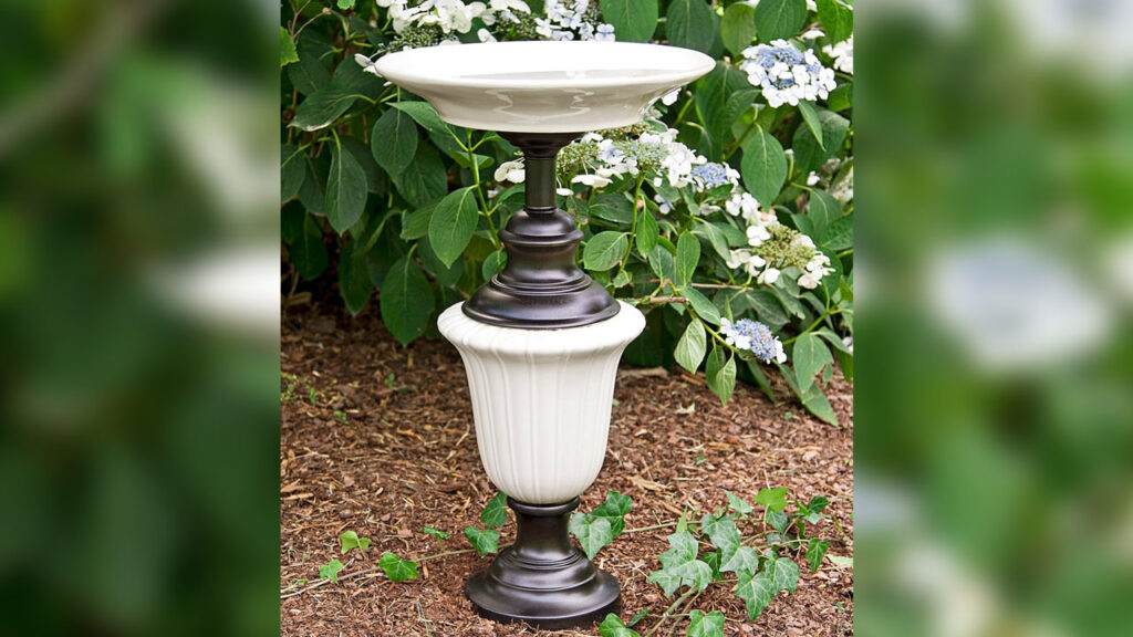 The DIY upcycled lamp birdbath looks like garden décor piece