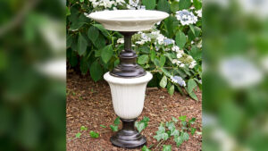 The DIY upcycled lamp birdbath looks like garden décor piece