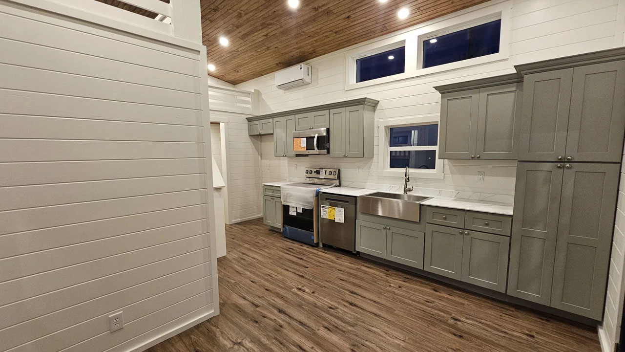 The sage green cabinetry offers ample storage and adds contemporary vibe to the space