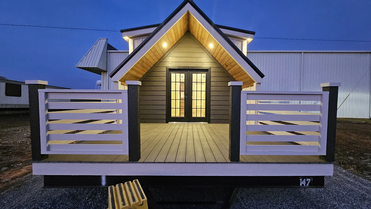 The steep gabled A-frame roof adds storybook charm to the tiny house
