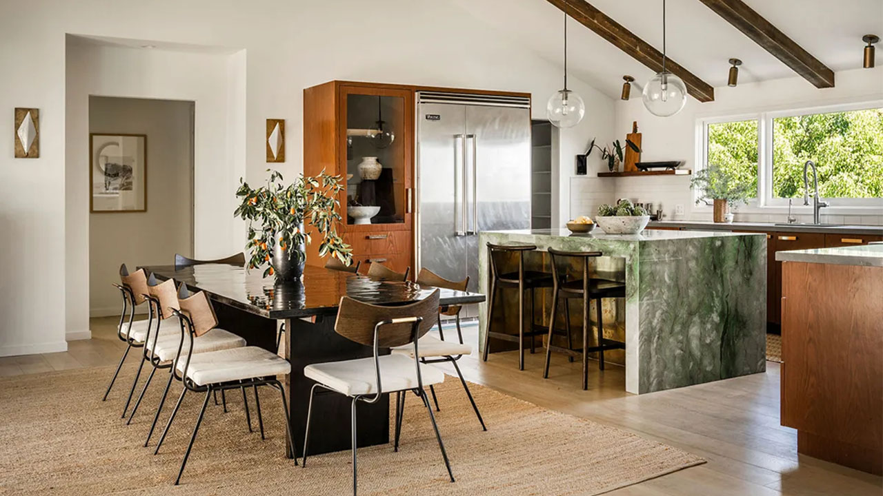 The green quartzite stone island anchors kitchen