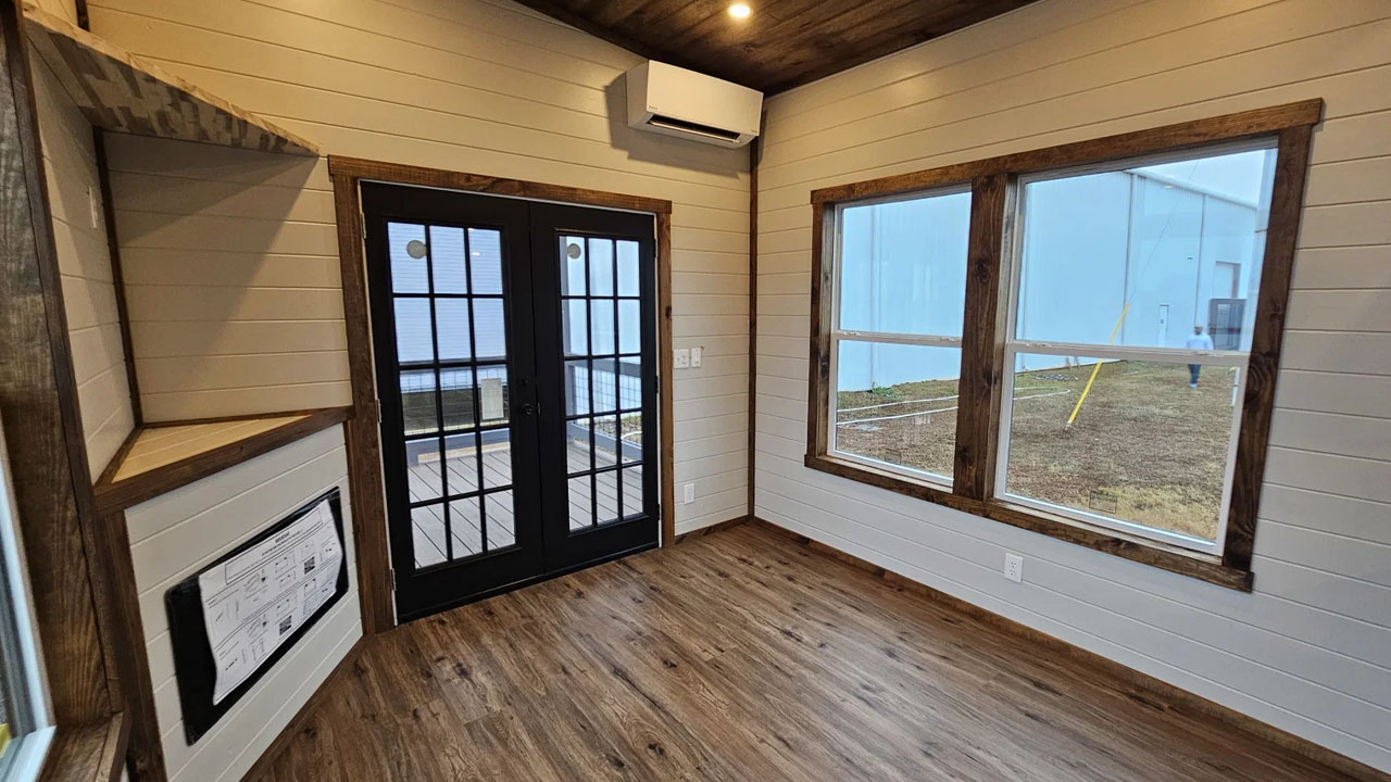 The French-style door and large vertical windows flood interior with plenty light
