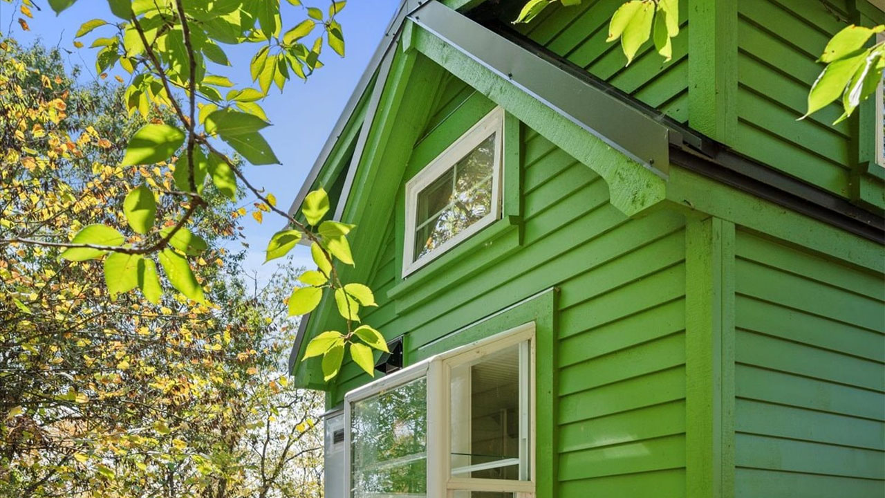 The close-up view of horizontal wooden lap-siding façade of the tiny house
