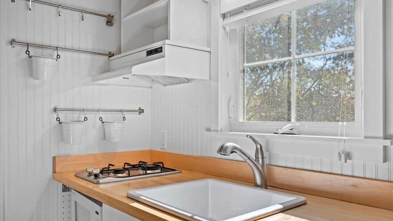 The flushed sink in the wooden kitchen countertop