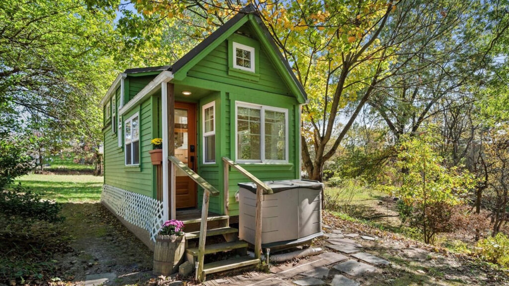 The charming mini cottage house beautifully blends into the woodland