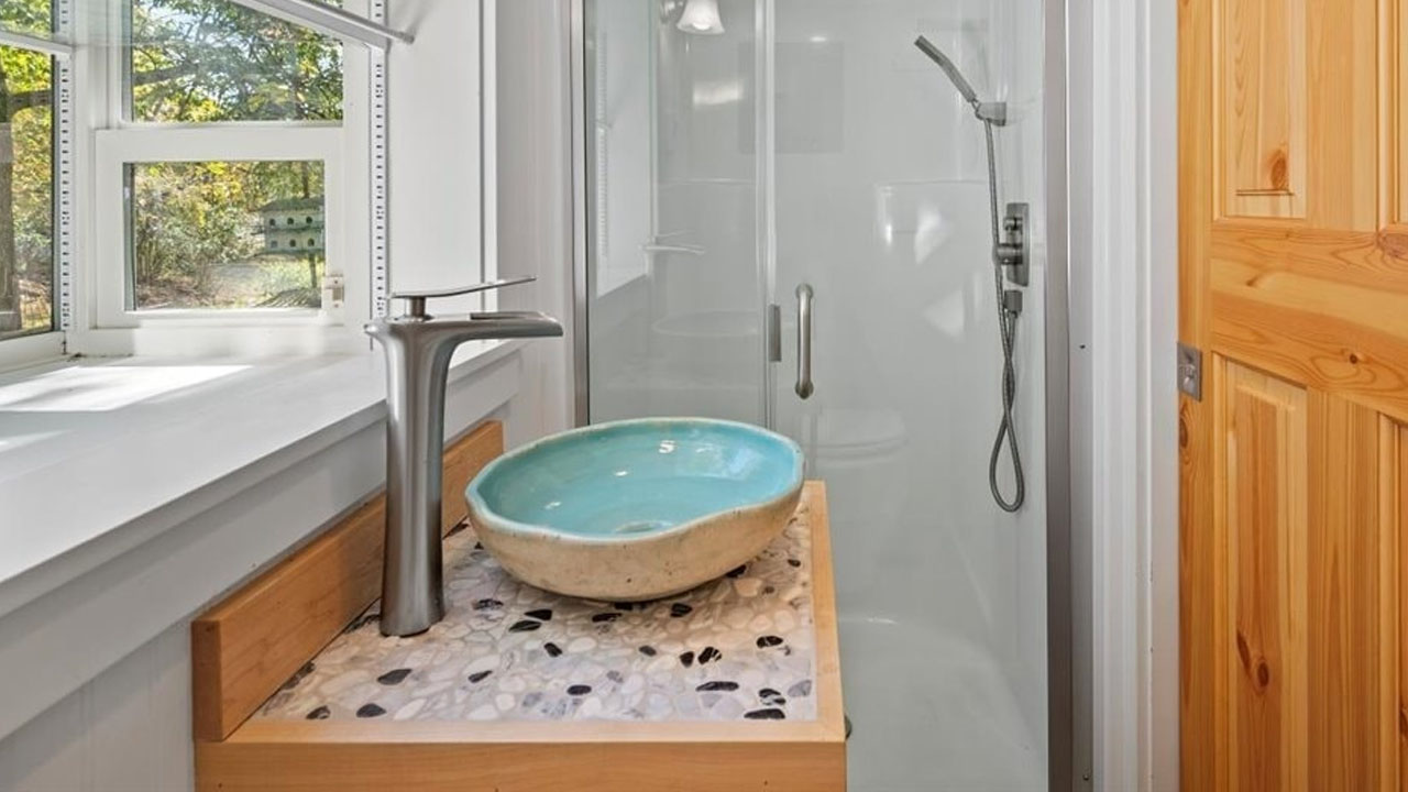 The stunning artisanal wash basin perched on mosaic pebble countertop
