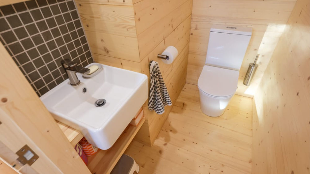 Th white washbasin besides the toilet