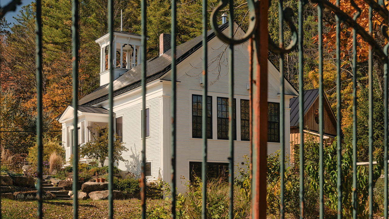 The modern black roof contrasts against the white exterior of the schoolhouse