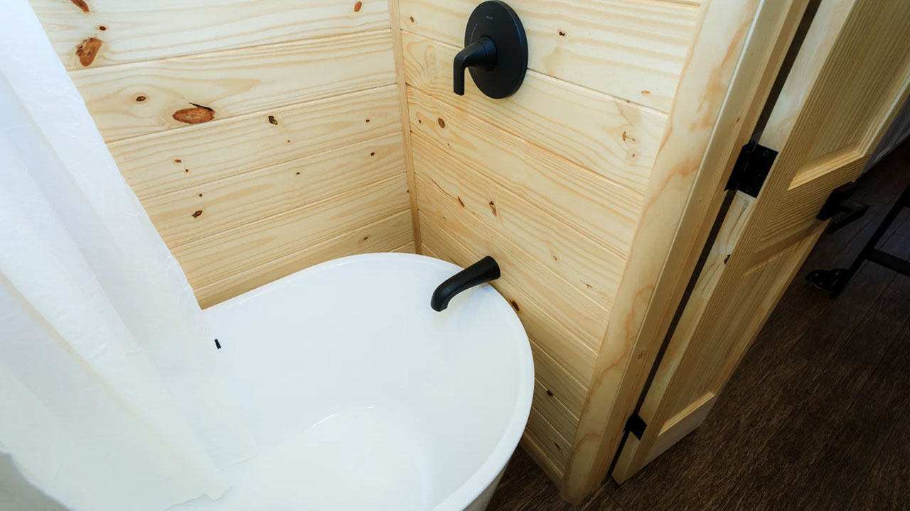 The bathtub with black accents fixed on walls