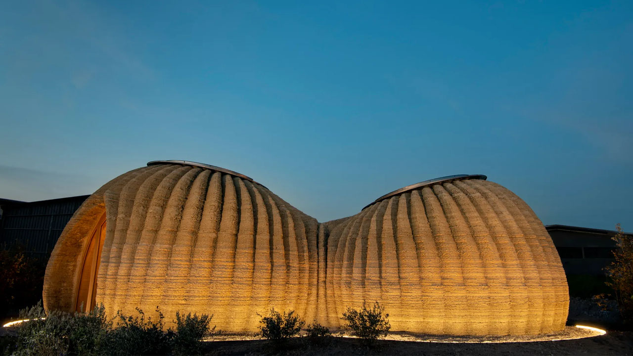 The beautiful, textured façade of Tecla glows during evening