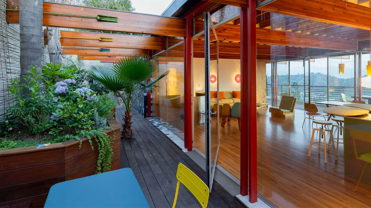the glazed door of living room open to the terrace with a garden
