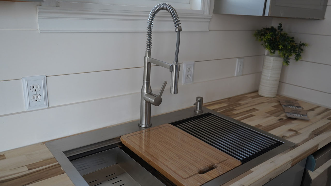 The pull-down spring faucet in the flushed sink