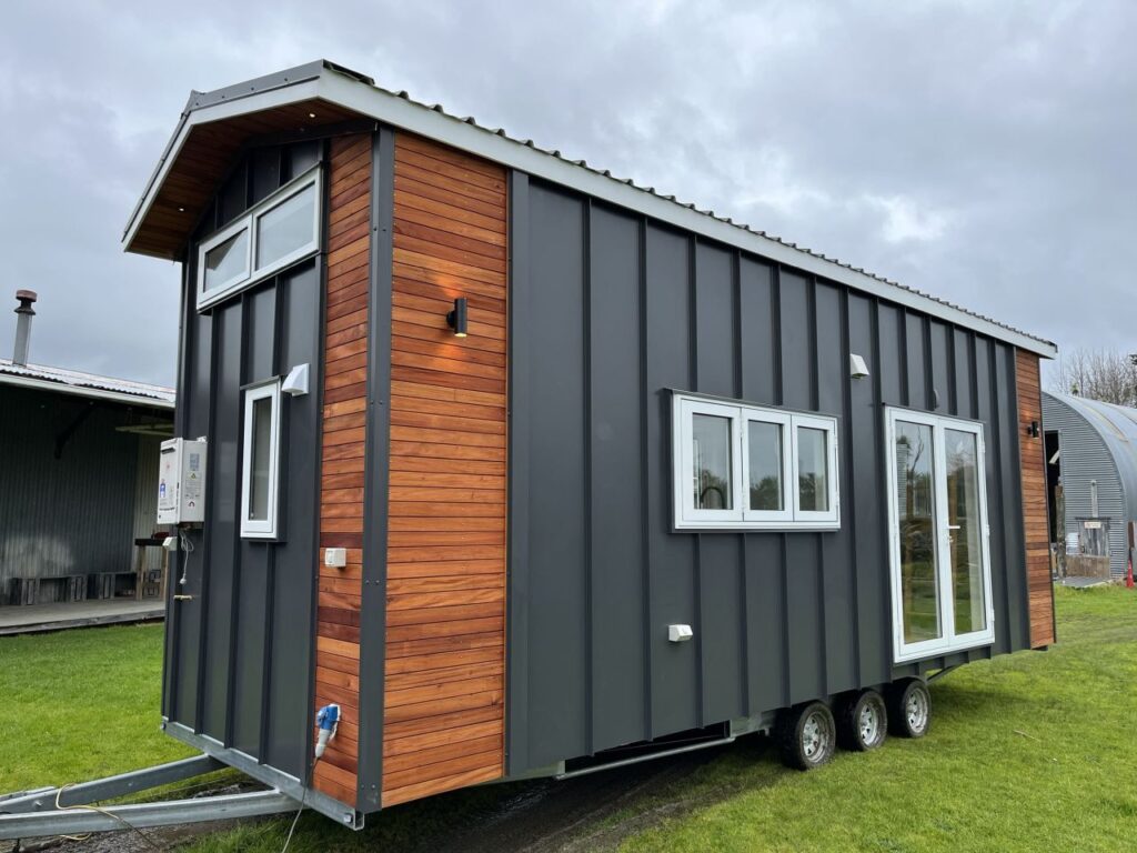 Maple Tiny House Features Overhang Shelf Above Kitchen for Extra Storage Smart Storage Hack