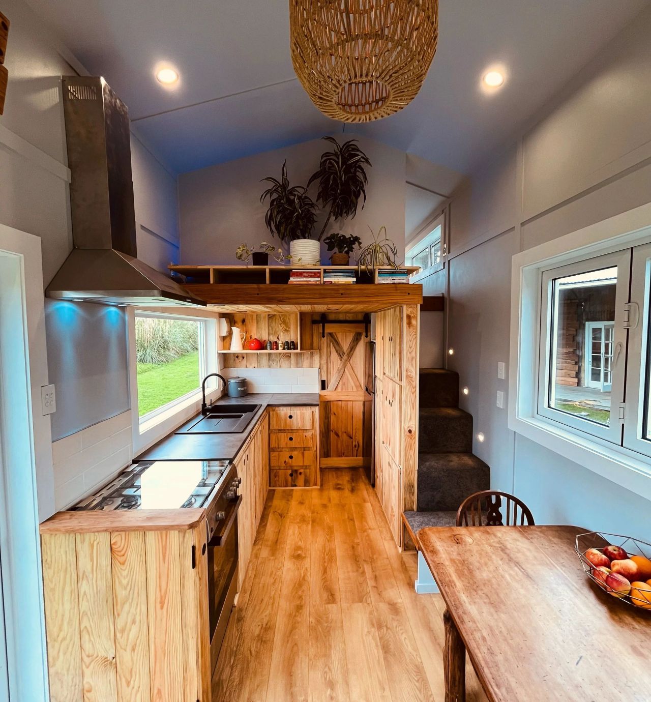 Maple Tiny House Features Overhang Shelf Above Kitchen for Extra Storage Smart Storage Hack
